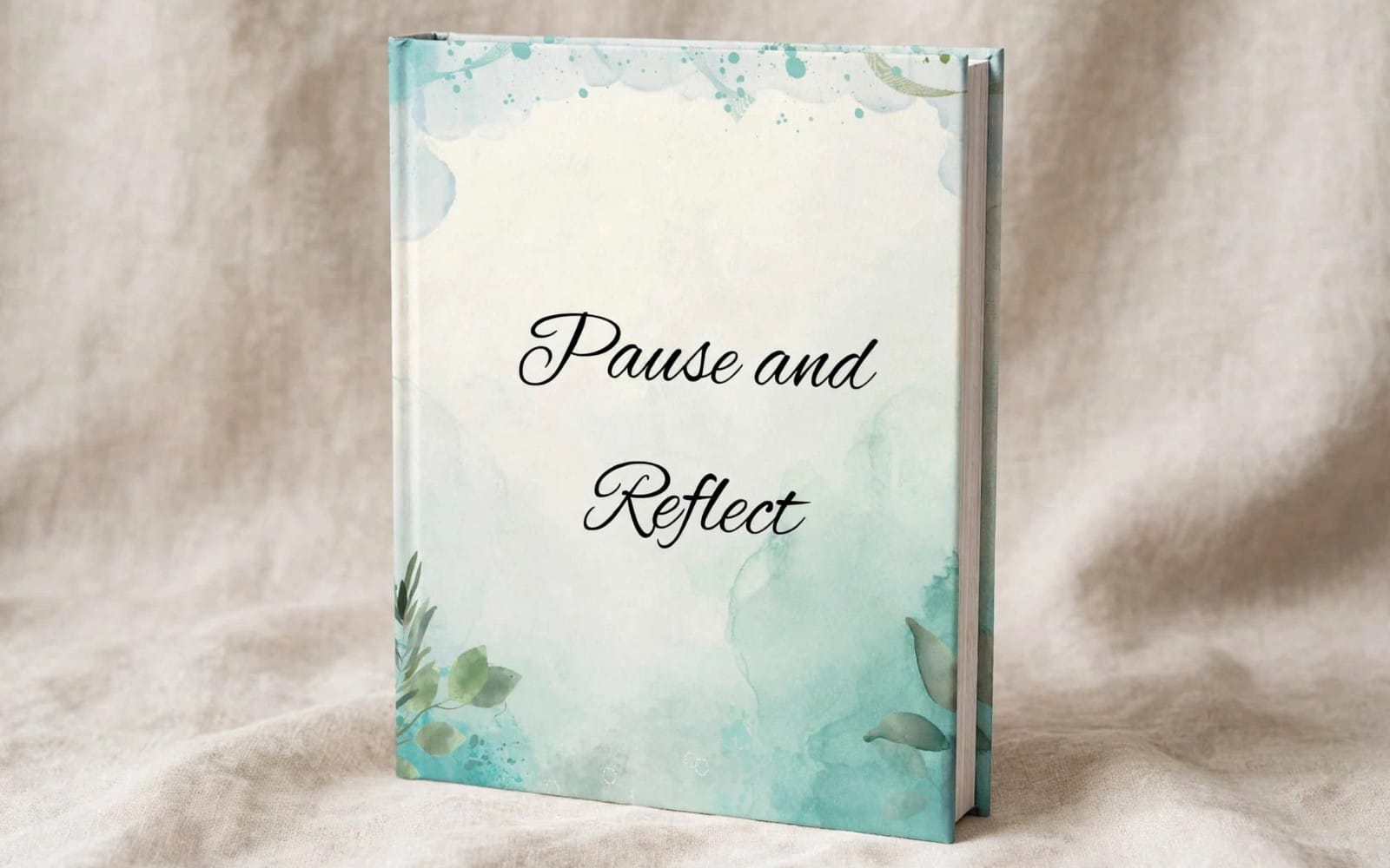 A “Pause and Reflect” journal with teal watercolor floral design on the cover