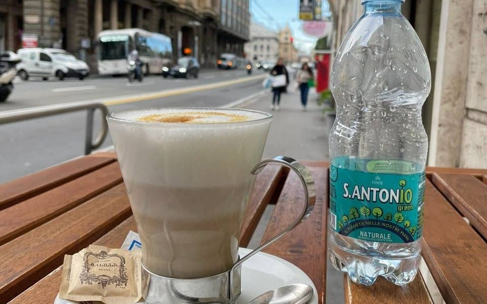 Café table scene with a glass of latte and water bottle, part of mixed photography collection food travel everyday life