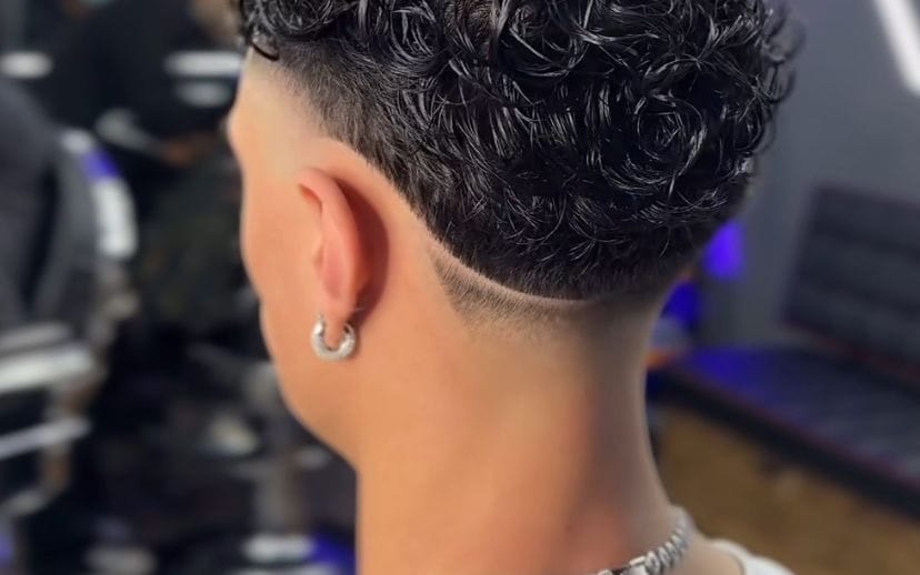 Close-up of a man’s ear with hoop earring and short hair in a styling service photo