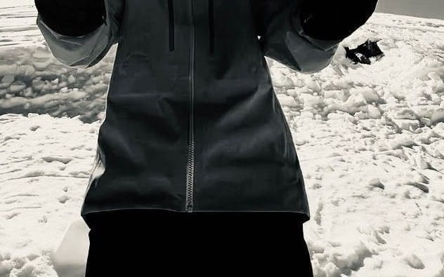 Black zip-up hoodie and pants set on snowy ground, outdoor clothing brand product shot